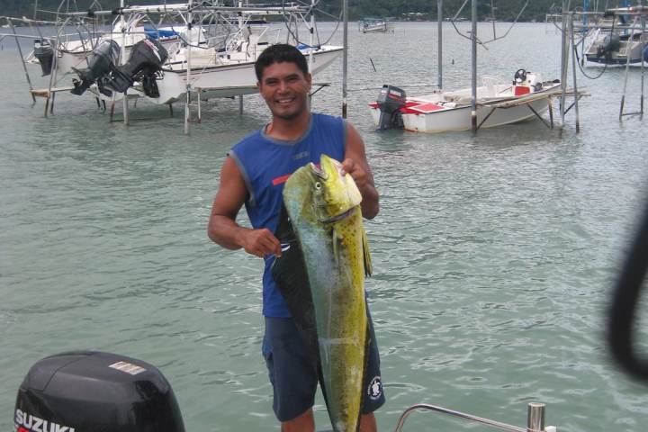 A guide holding a fish after a fishing tour in Bora Bora