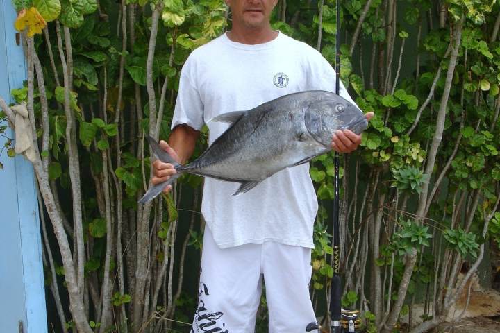 A client holding a fish after a fishing tour in Bora Bora