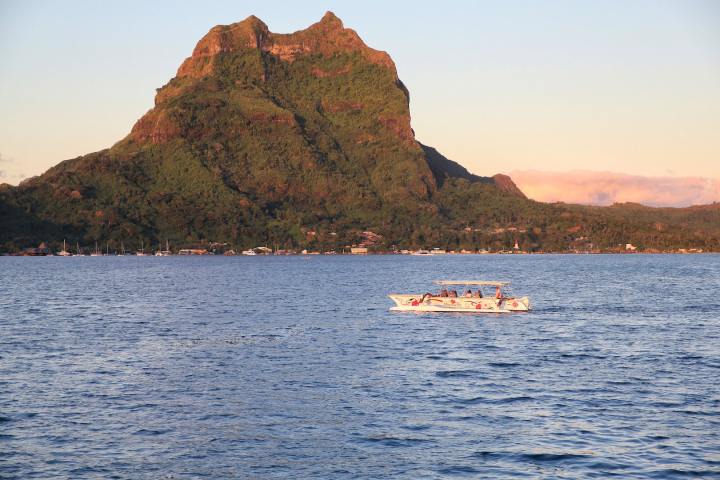 A Polynesian outrigger sailing in Bora Bora