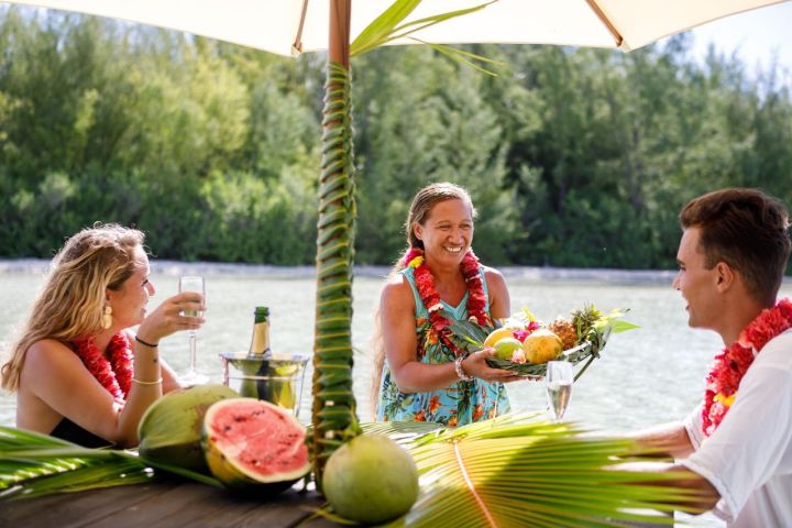 A couple having a glass of champagne on a motu in Bora Bora