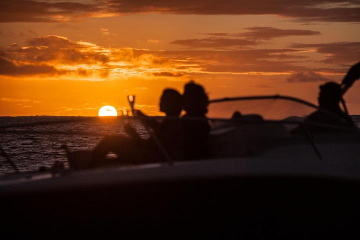 A couple having a glass of champagne onboard watching Bora Bora sunset