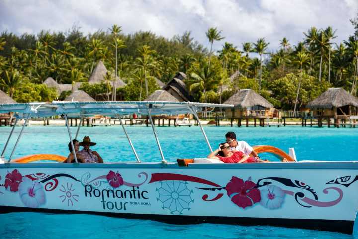 Two couples sailing on a Polynesian outrigger In Bora Bora
