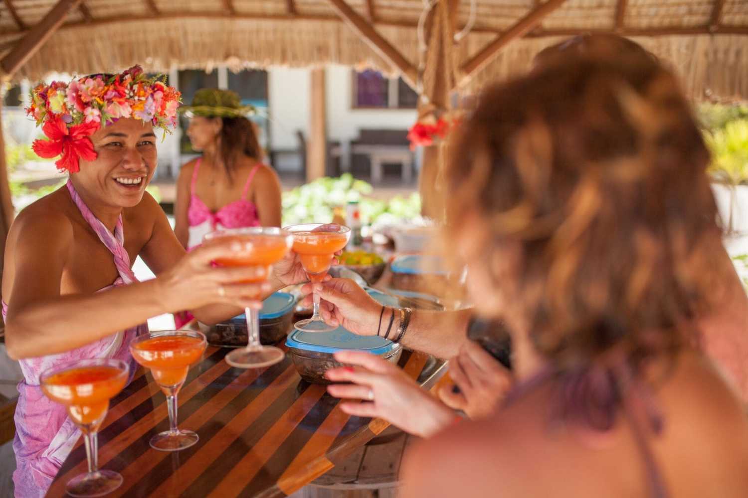 A group of people having a welcome cocktail on a motu in Bora Bora