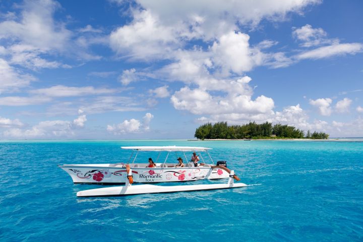 Two couples sailing on a Polynesian outrigger In Bora Bora