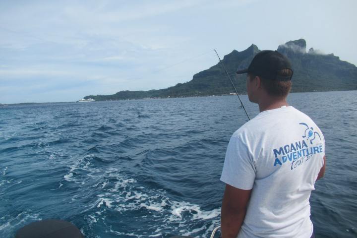 A guide showing how to fish to clients in Bora Bora lagoon