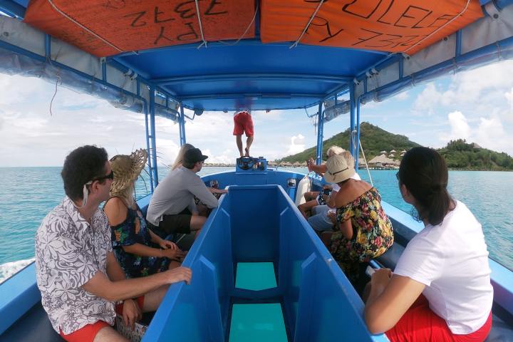 A group of people enjoying a glass bottom boat tour in Bora Bora