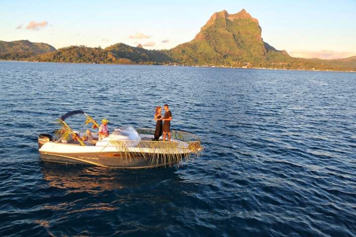 A couple having a glass of champagne onboard watching Bora Bora sunset