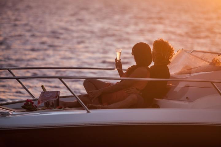 A couple having a glass of champagne onboard watching Bora Bora sunset