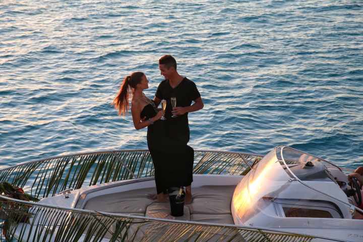 A couple having a glass of champagne onboard watching Bora Bora sunset