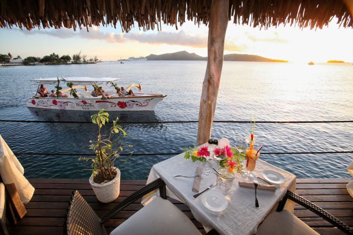 A Polynesian outrigger arriving at Saint James restaurant in Bora Bora