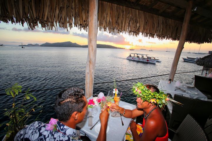 A Polynesian outrigger arriving at Saint James restaurant in Bora Bora