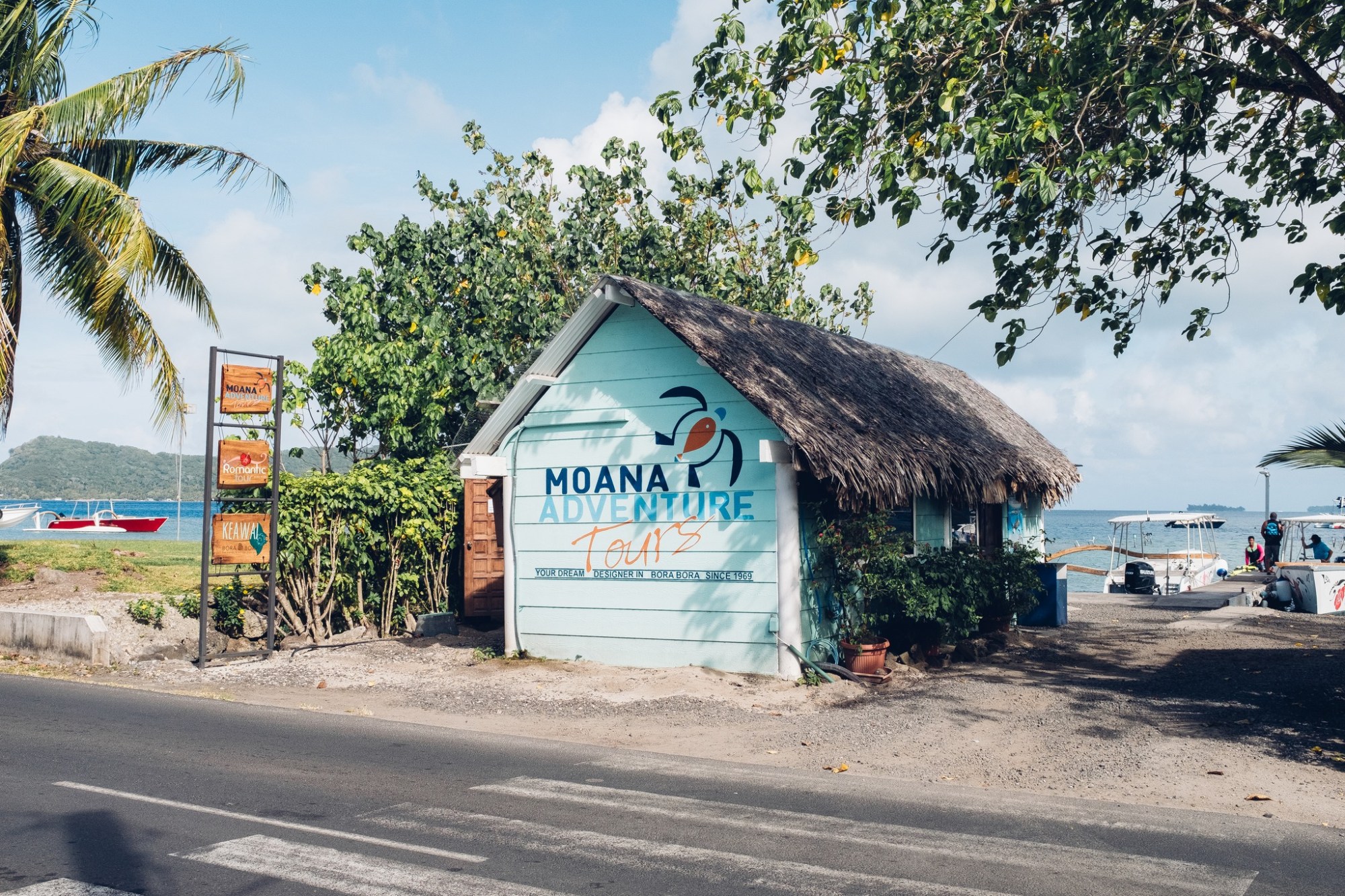 a house that has a sign on a dirt road